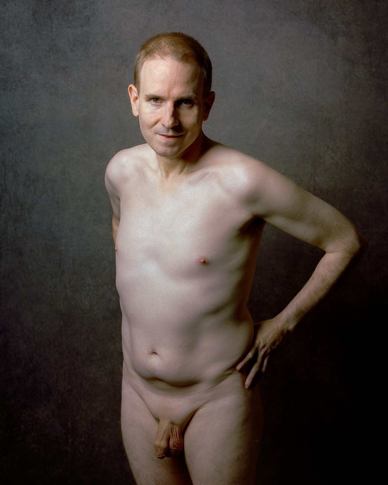 SJ Nude standing fully nude with a hand on his hip, gray backdrop, medium format Kodak Portra 400, San Jose