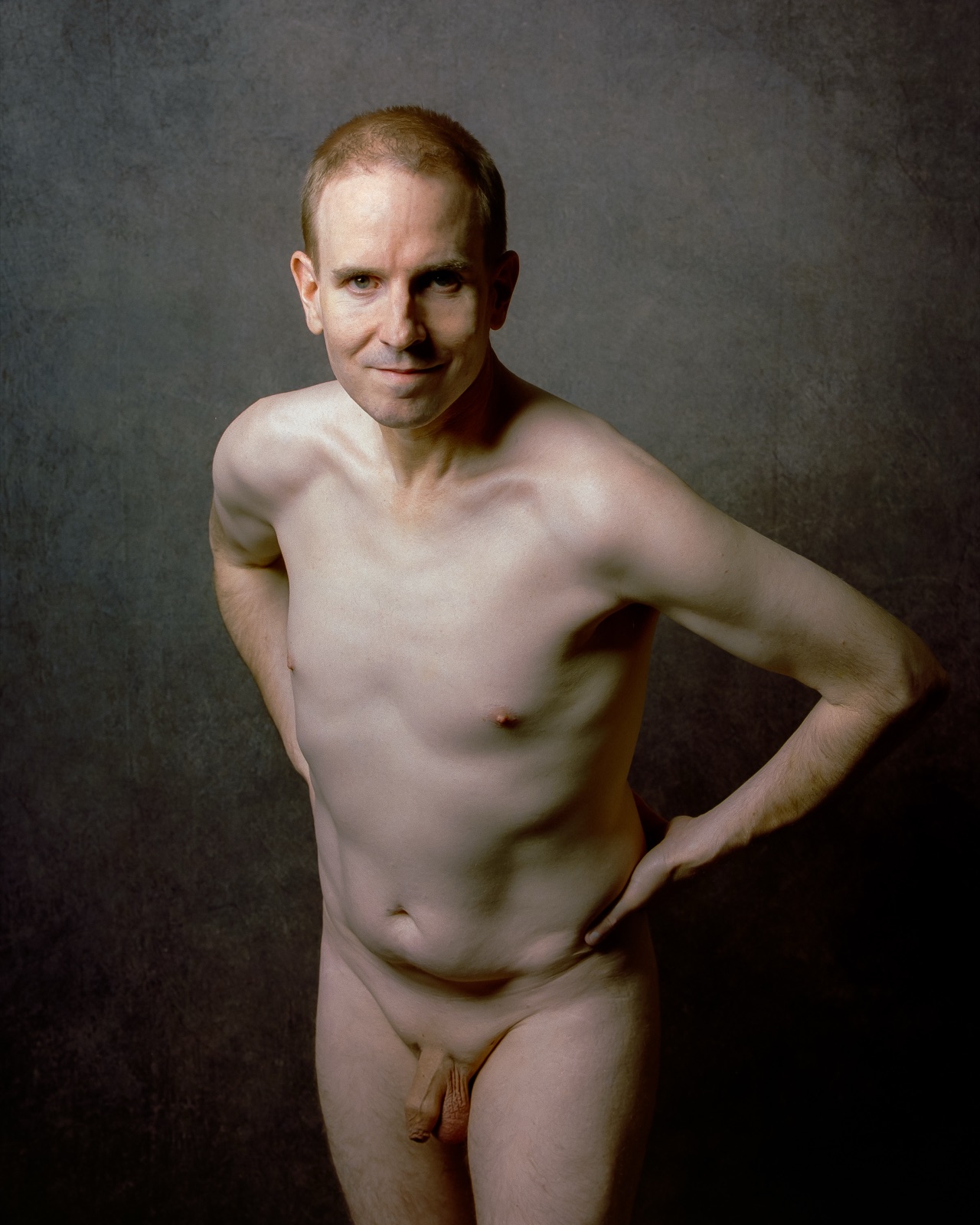 SJ Nude standing fully nude, other hand on his hip, gray backdrop, medium format Portra 400, San Jose
