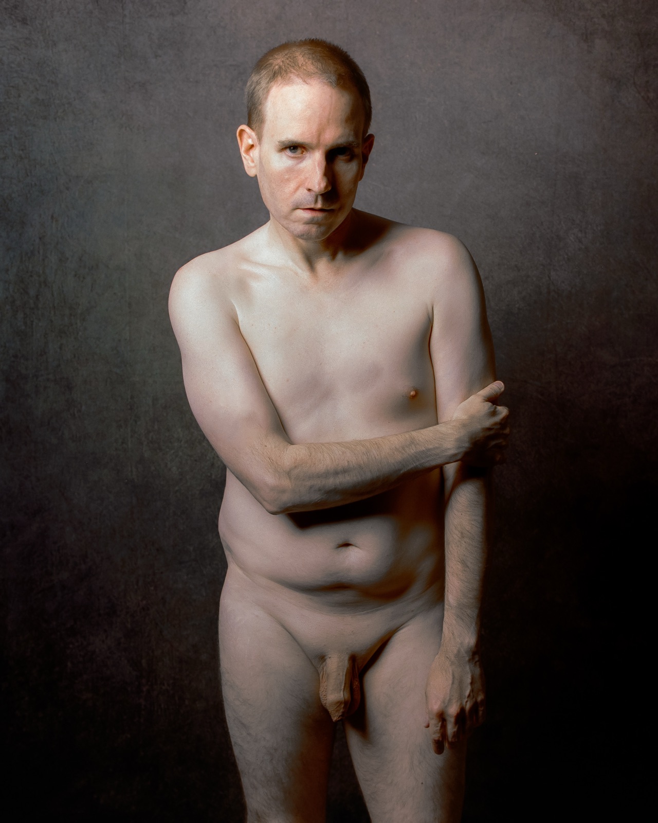 SJ Nude standing fully nude with an arm across his chest, gray backdrop, Portra 400, San Jose